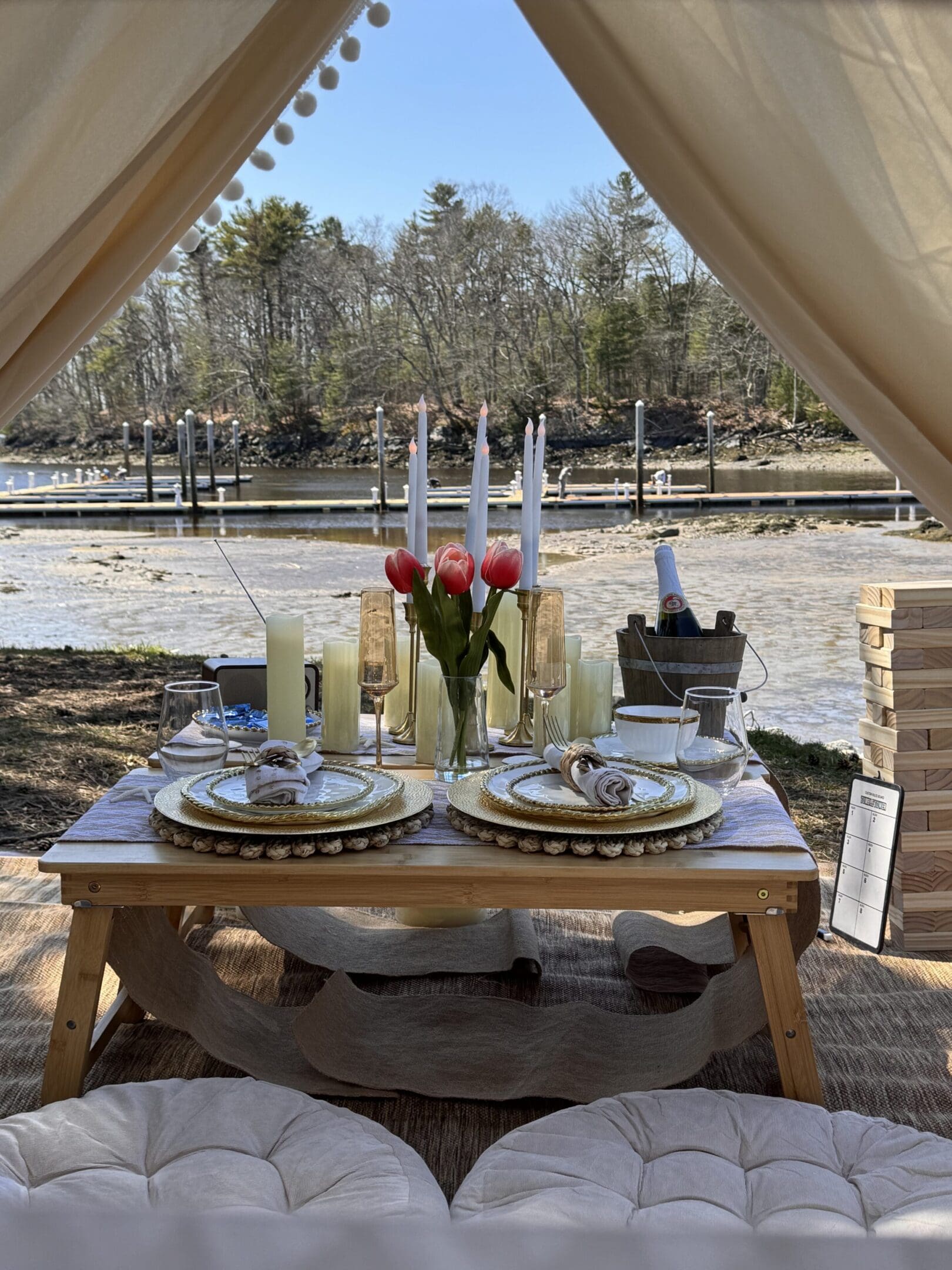 Elegant outdoor dining setup with flowers and candles under a canopy.